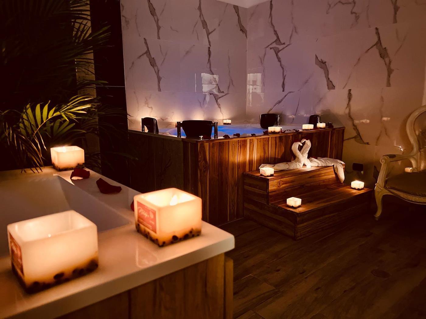 Cabina con tina de mármol, velas y madera