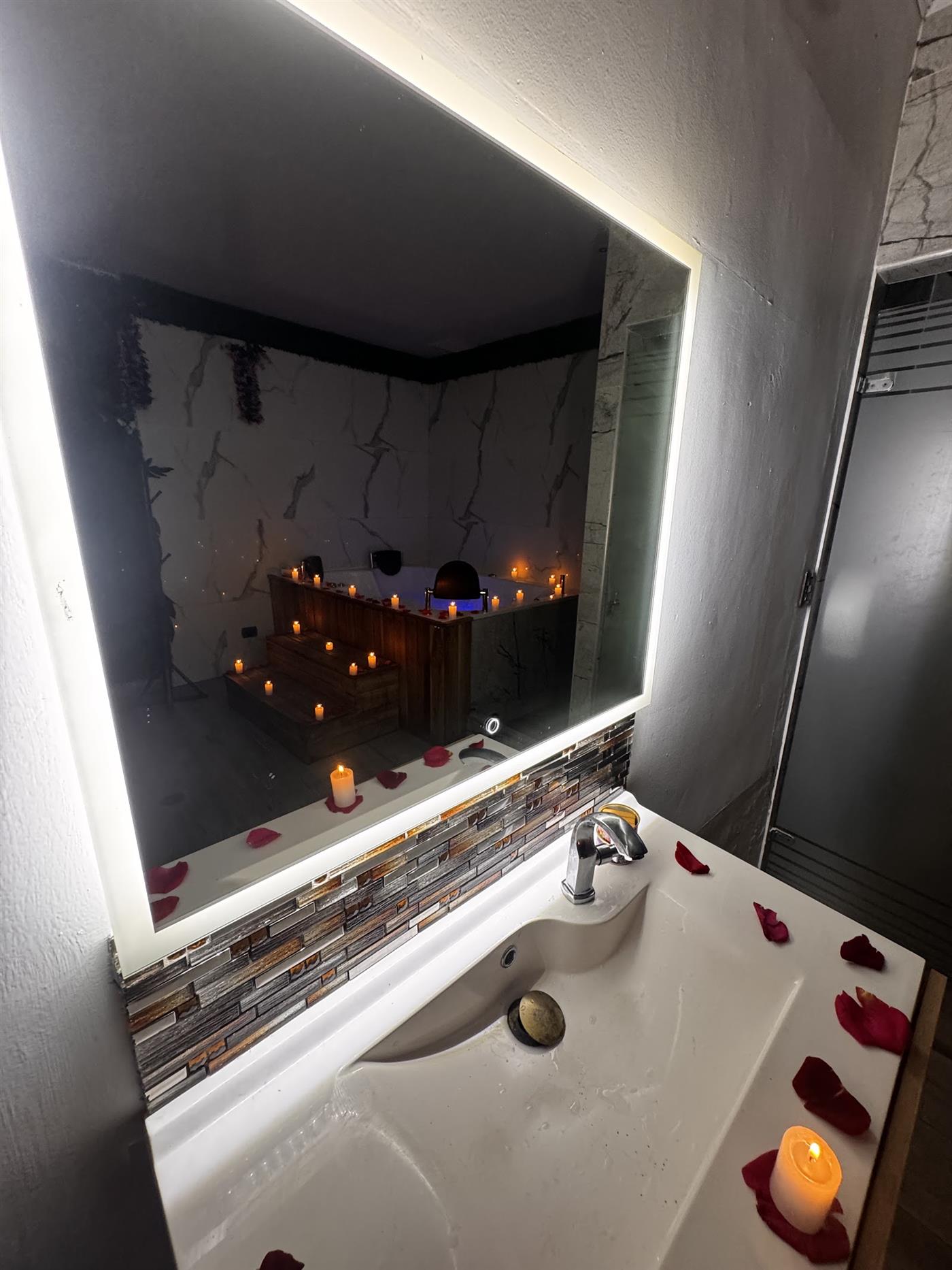 Espejo iluminado y lavamanos con velas